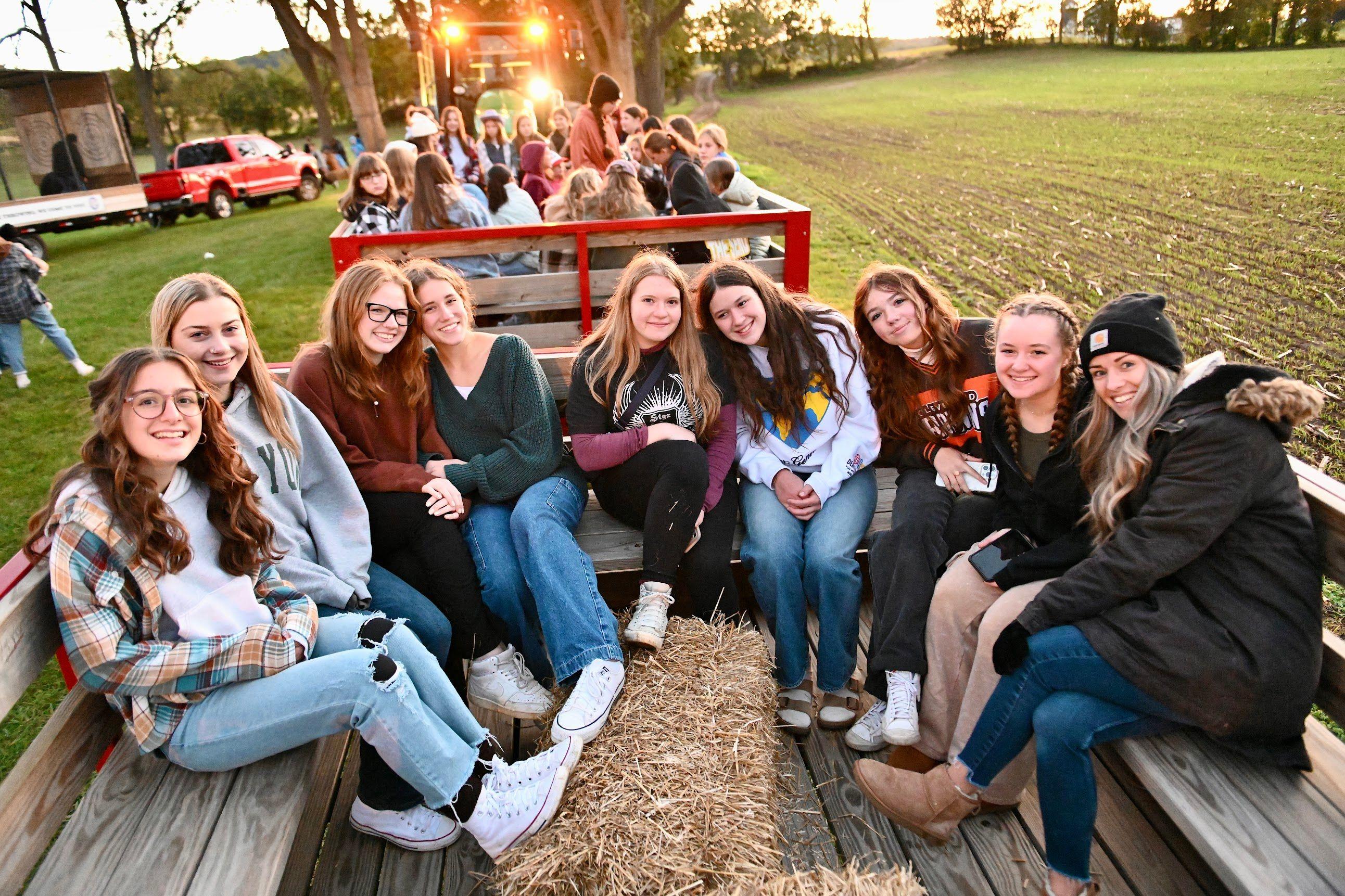 Friends on a wagon ride at harvest youth event.