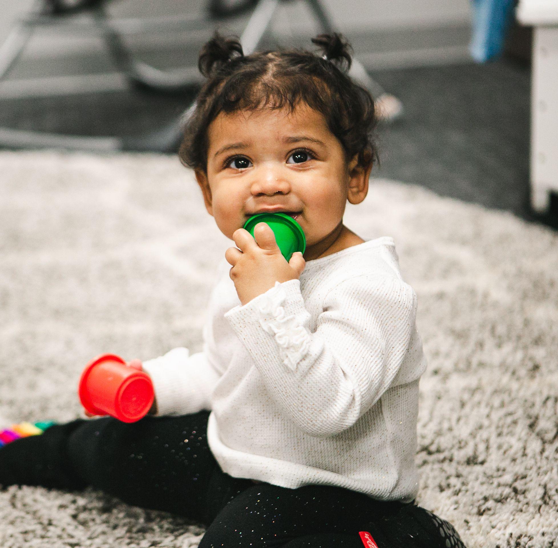 Baby playing with colored cups.